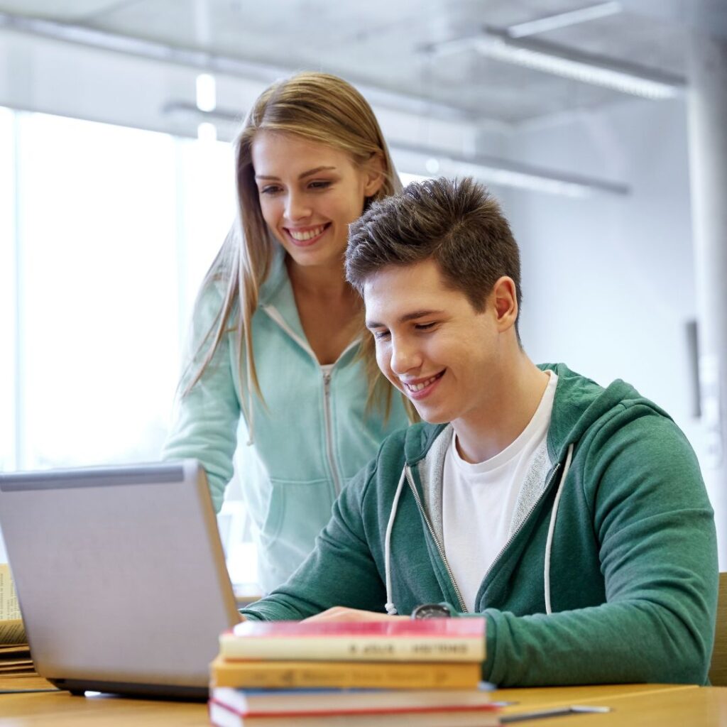 two teens looking at laptop