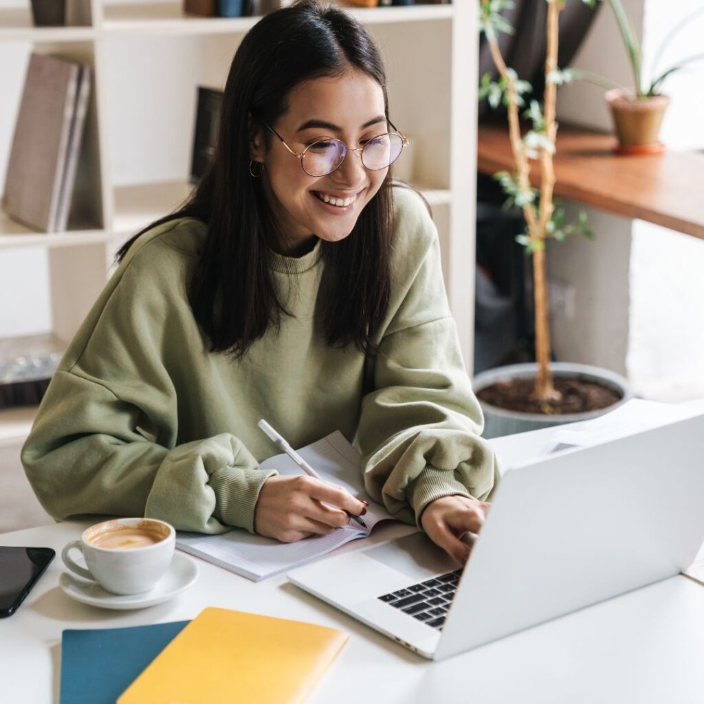 smiling teenage girl working on laptop