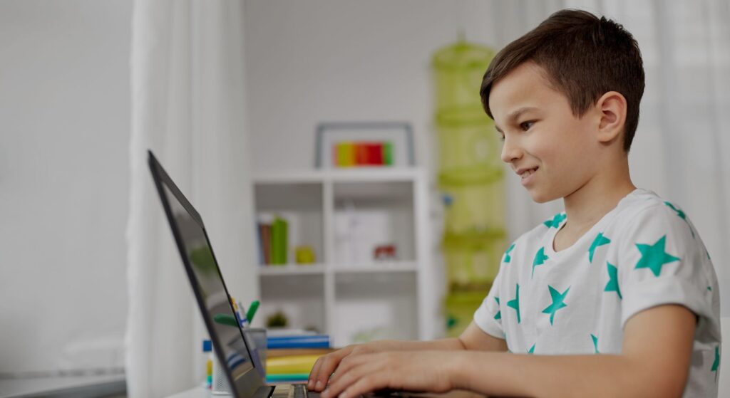 smiling boy working on laptop