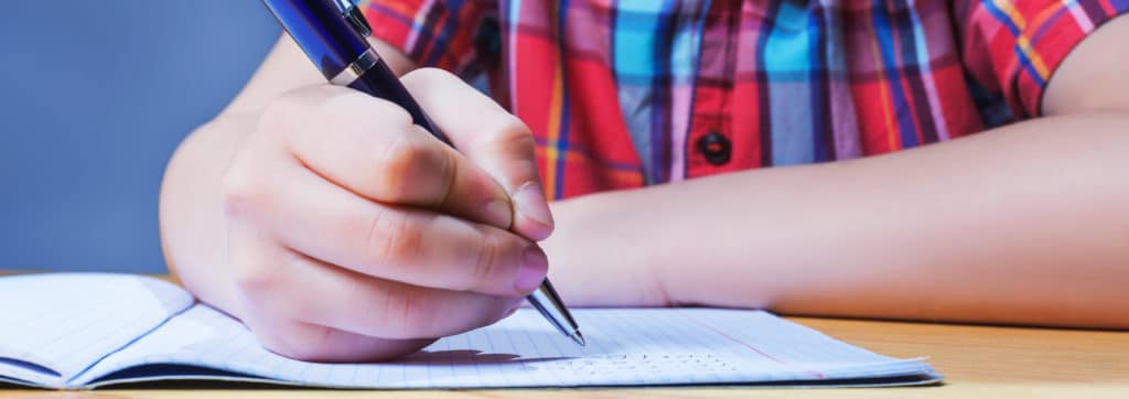 boy writing on graph paper