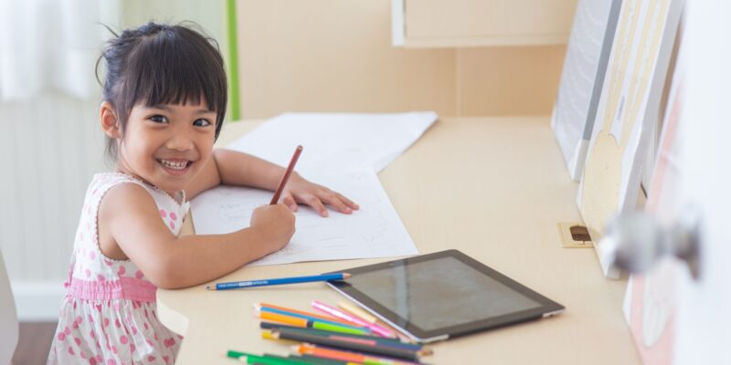 a girl writing at her desk at home