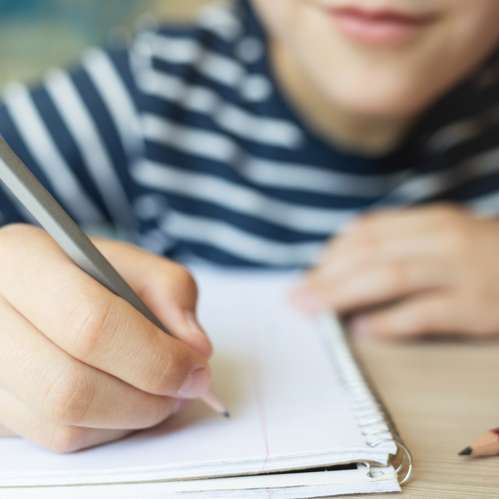 a close up of someone holding a pencil, about to write in a notebook